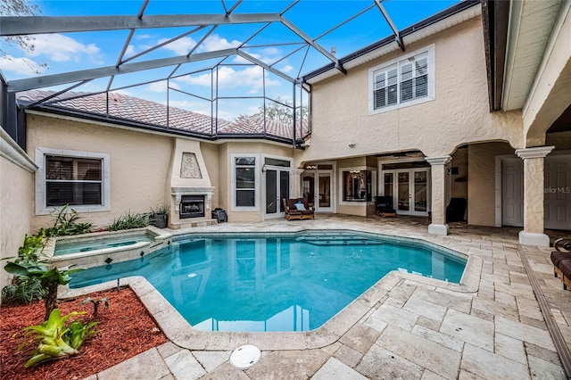 view of pool with a patio, an outdoor fireplace, a lanai, and a pool with connected hot tub