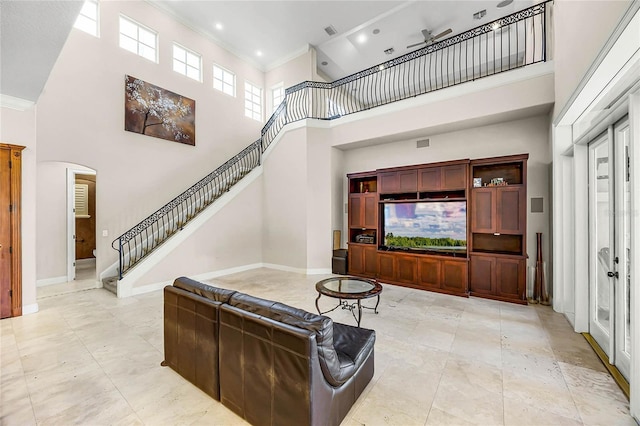 living room with ornamental molding, stairway, a high ceiling, and baseboards