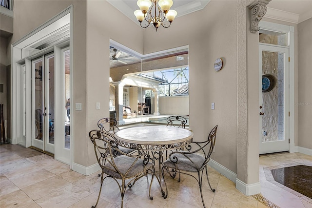 dining space featuring baseboards, a textured wall, ornamental molding, french doors, and a notable chandelier