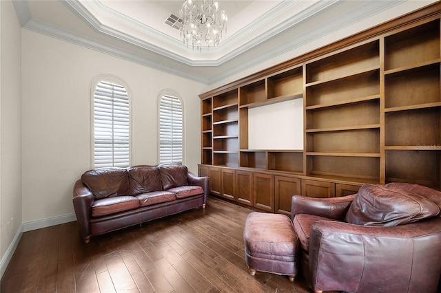 living room featuring baseboards, a raised ceiling, dark wood-style floors, crown molding, and a notable chandelier