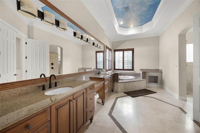 bathroom with a bath, plenty of natural light, a tray ceiling, and crown molding