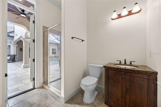 bathroom featuring toilet, vanity, a shower stall, and a wealth of natural light