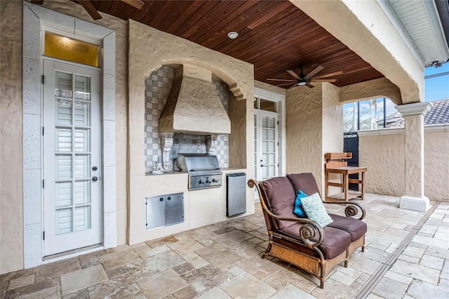 view of patio with ceiling fan, an outdoor kitchen, area for grilling, and fence