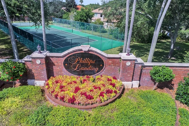 community / neighborhood sign featuring a yard and fence