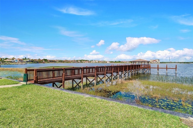 dock area with a water view and a lawn