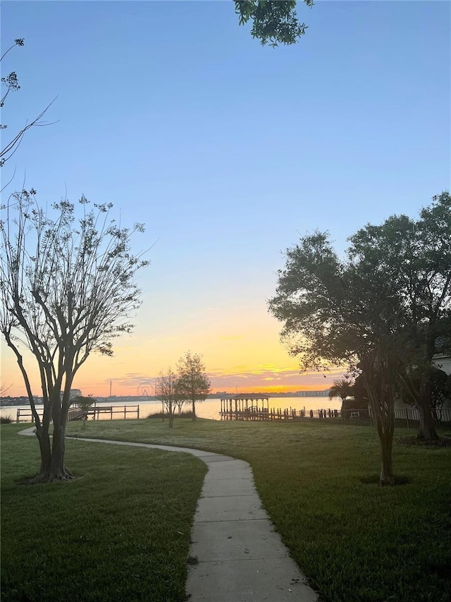 view of home's community with a yard and a water view