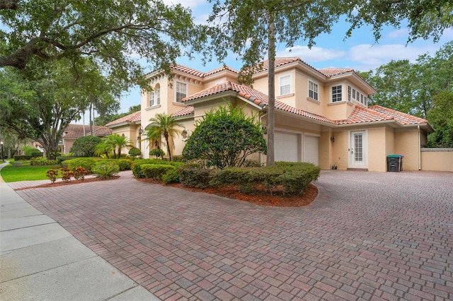 8814 Southern Breeze Dr, Orlando, FL 32836 - mediterranean / spanish-style house with stucco siding, an attached garage, a tiled roof, and decorative driveway