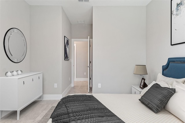 bedroom with light tile patterned floors, visible vents, and baseboards