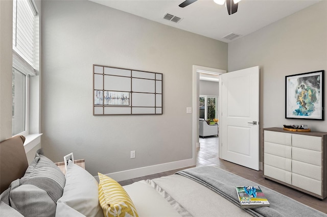 bedroom with a ceiling fan, tile patterned flooring, visible vents, and baseboards