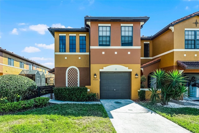 view of front of house featuring driveway, an attached garage, fence, and stucco siding