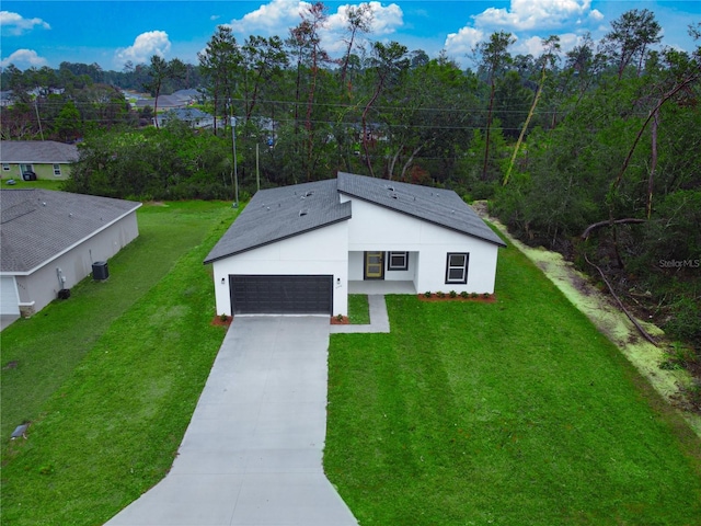 view of front of house featuring an attached garage, stucco siding, driveway, and a front yard