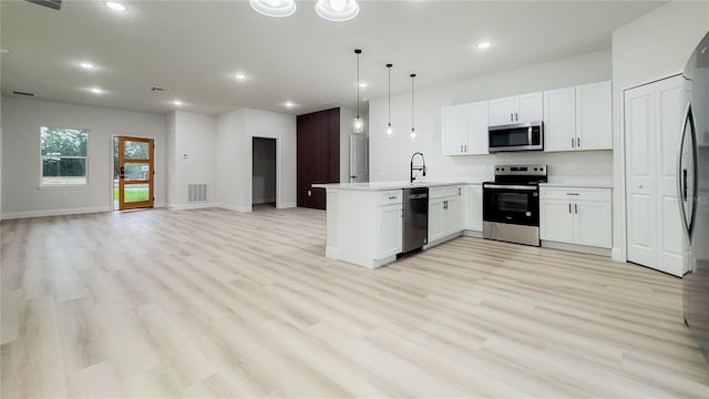 2246 SW 167th Pl, Ocala, FL 34475 - kitchen with stainless steel appliances, a peninsula, open floor plan, recessed lighting, and light wood-style floors