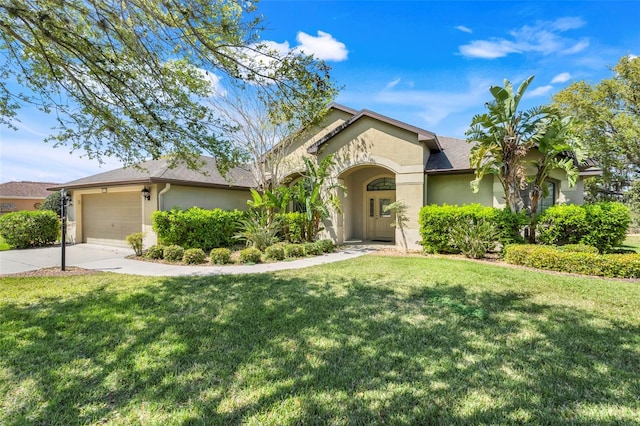 view of front of home with concrete driveway, a garage, a front yard, and stucco siding