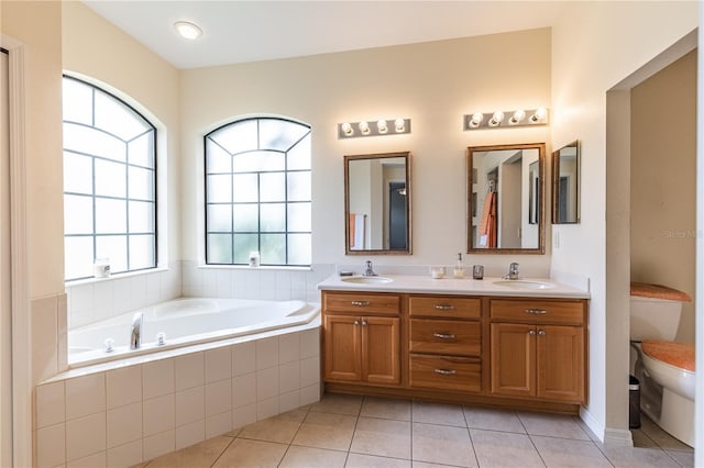 full bath featuring a sink, a garden tub, double vanity, and toilet