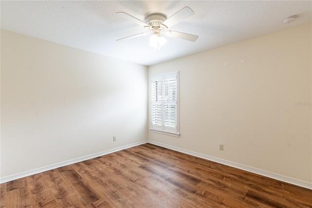 empty room with baseboards, a textured ceiling, and wood finished floors