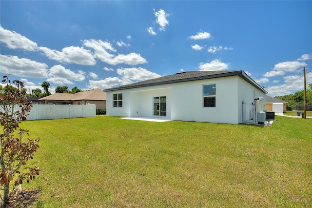 back of property with a patio, a lawn, fence, and stucco siding