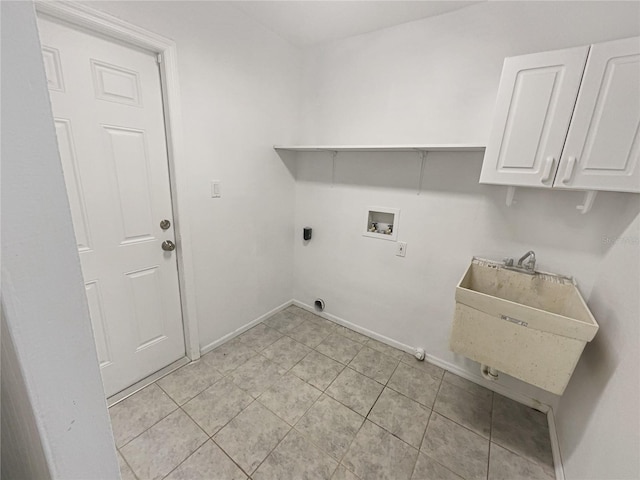 washroom featuring light tile patterned floors, hookup for a washing machine, cabinet space, a sink, and baseboards