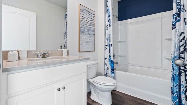 bathroom with toilet, shower / tub combo with curtain, wood finished floors, and vanity