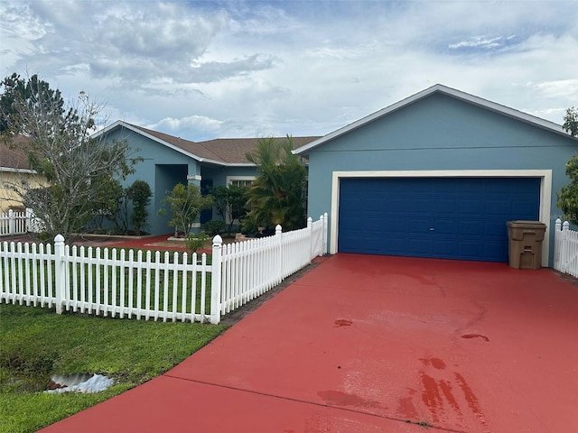 ranch-style home with a garage, a fenced front yard, and stucco siding