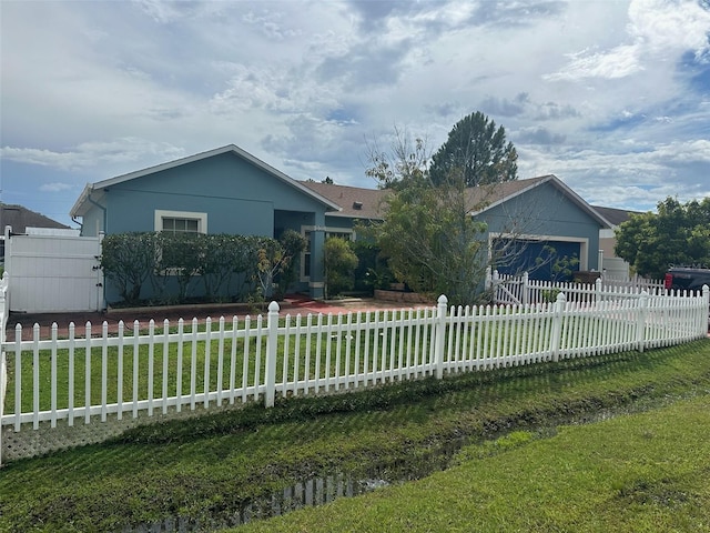 single story home with a garage, a front lawn, a fenced front yard, and stucco siding