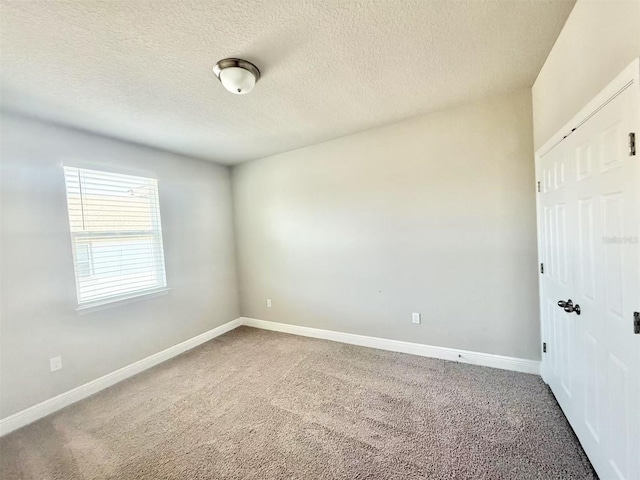 unfurnished bedroom featuring a closet, carpet flooring, a textured ceiling, and baseboards