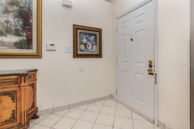 foyer featuring light tile patterned flooring and baseboards