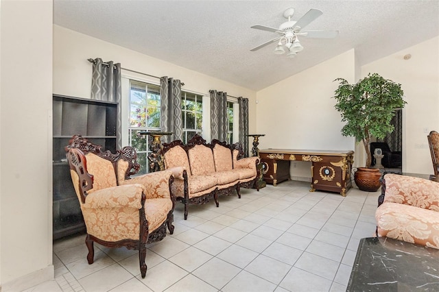 living room featuring lofted ceiling, a textured ceiling, light tile patterned flooring, and a ceiling fan