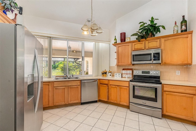 kitchen featuring light tile patterned floors, decorative backsplash, appliances with stainless steel finishes, light countertops, and a sink