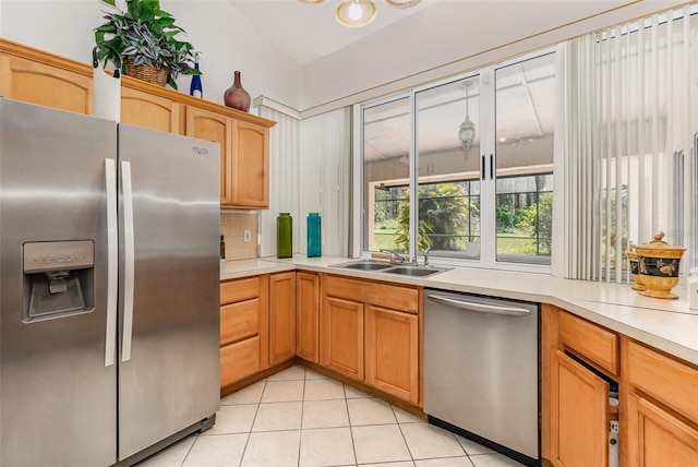 kitchen with light tile patterned flooring, a sink, light countertops, appliances with stainless steel finishes, and backsplash