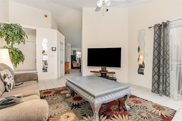 living area with light tile patterned floors, ceiling fan, and a high ceiling