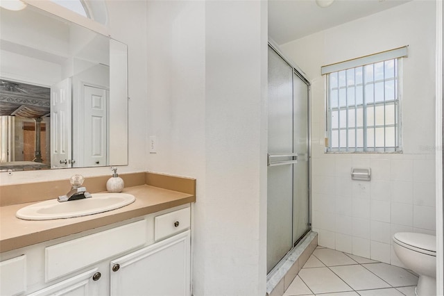 full bathroom featuring a stall shower, tile patterned flooring, toilet, and tile walls