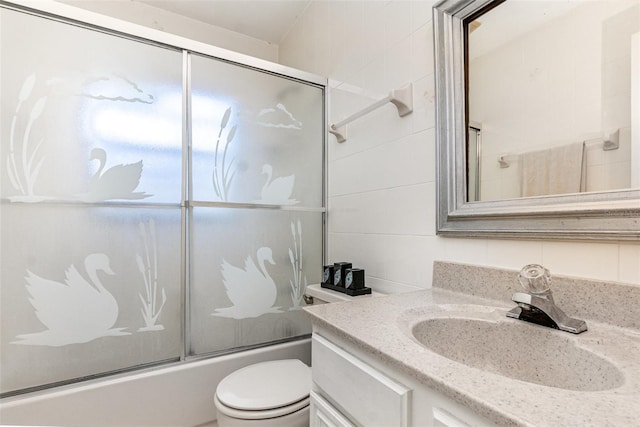 full bath featuring enclosed tub / shower combo, vanity, and toilet