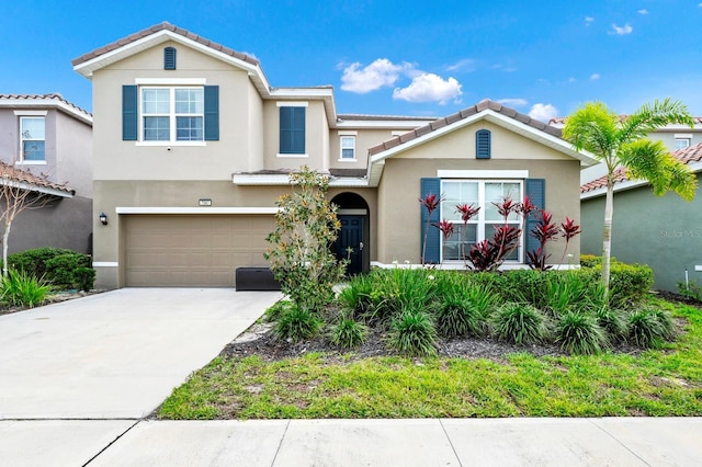 view of front facade featuring driveway, an attached garage, a tiled roof, and stucco siding