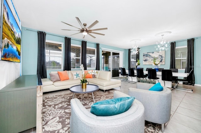 living area featuring light tile patterned floors and ceiling fan with notable chandelier