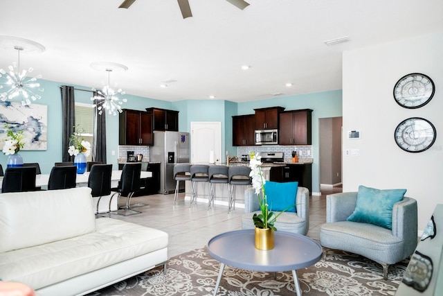 living area featuring recessed lighting, visible vents, ceiling fan with notable chandelier, and light tile patterned flooring