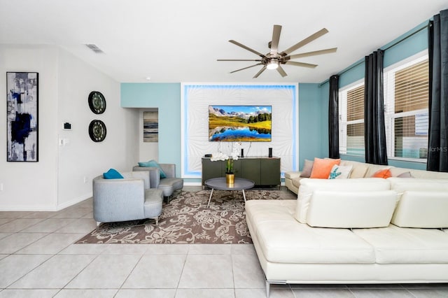 living area featuring ceiling fan, light tile patterned flooring, visible vents, and baseboards