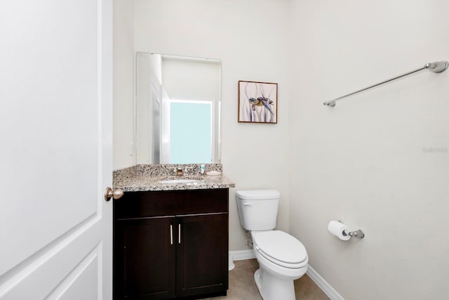 bathroom with toilet, tile patterned flooring, vanity, and baseboards