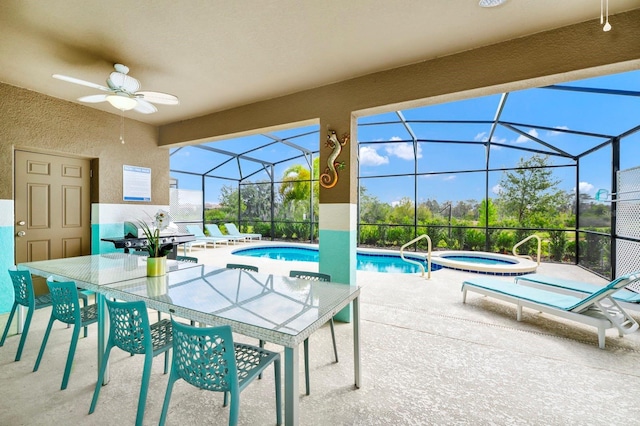 view of swimming pool featuring glass enclosure, a patio area, and a pool with connected hot tub