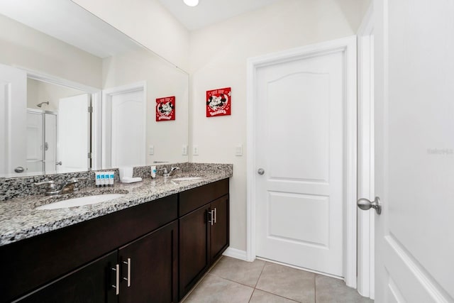 full bath featuring tile patterned flooring, a shower with door, a sink, and double vanity