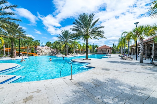 pool featuring a gazebo, a water slide, and a patio area