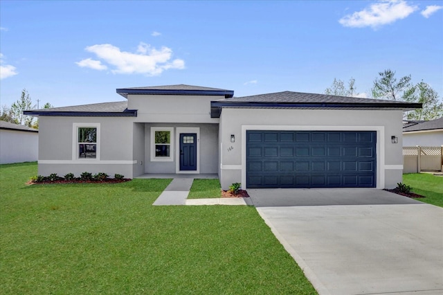 prairie-style home featuring stucco siding, concrete driveway, and a front lawn