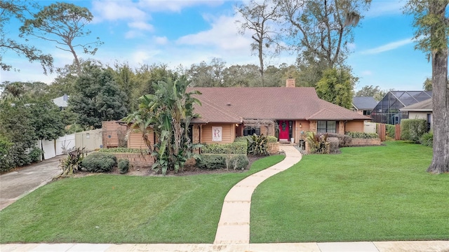 ranch-style house featuring a shingled roof, a chimney, fence, and a front yard