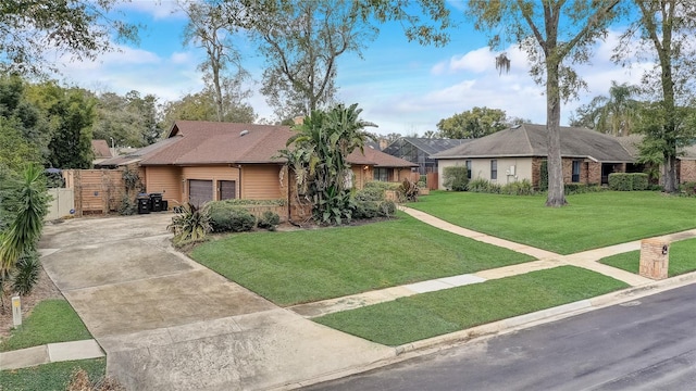 ranch-style home with an attached garage, concrete driveway, brick siding, and a front yard