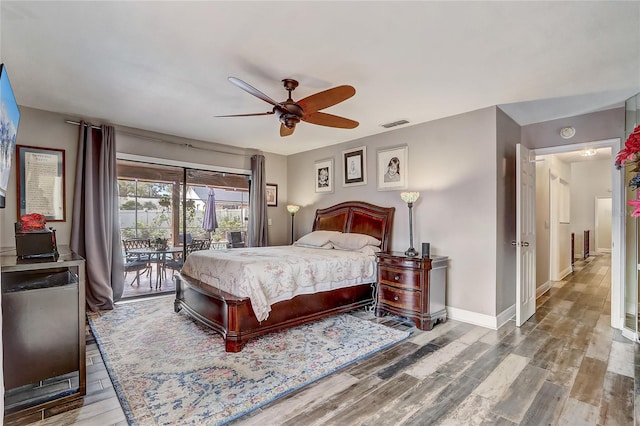 bedroom featuring baseboards, visible vents, ceiling fan, wood finished floors, and access to outside