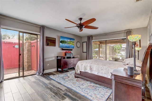 bedroom with access to outside, multiple windows, wood finished floors, and baseboards