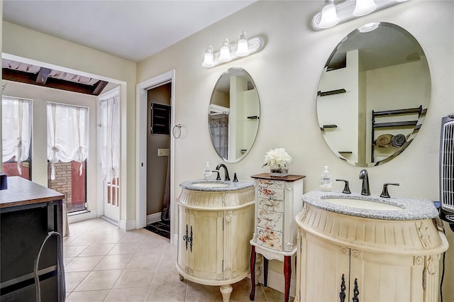 bathroom featuring tile patterned flooring, two vanities, a sink, and baseboards