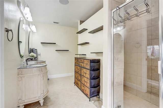 full bath featuring tile patterned floors, baseboards, a stall shower, and vanity