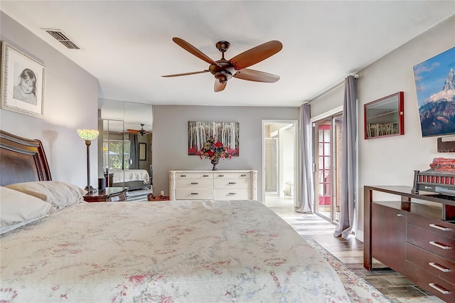 bedroom featuring light wood-style floors, visible vents, and ceiling fan