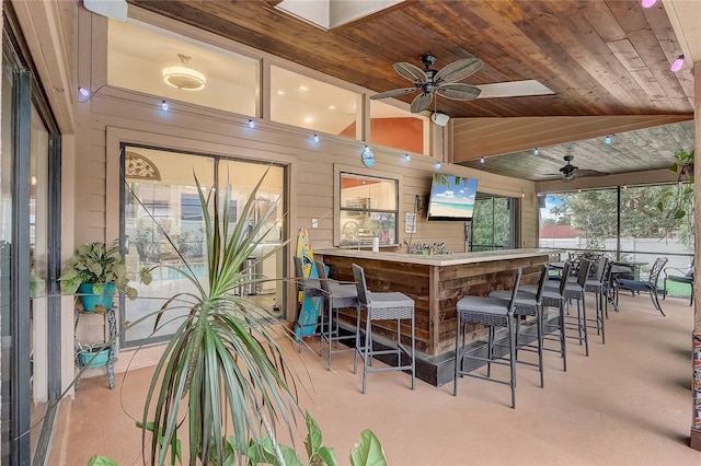 bar featuring lofted ceiling, wooden ceiling, wooden walls, and a dry bar