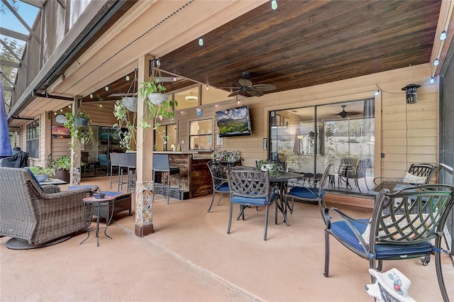 view of patio with outdoor dry bar, outdoor dining area, and a ceiling fan